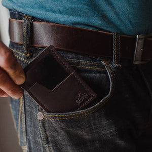 a Solid Leather dark brown minimalist wallet in the front pocket of jeans 