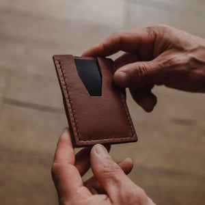 mans hands holding a slim minimalist cardholder wallet by Solid Leather 