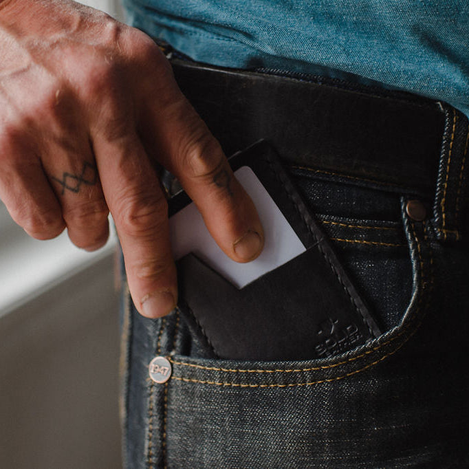 Slim Leather Card Holder wallet in black by Solid Leather in a front pocket of jeans.