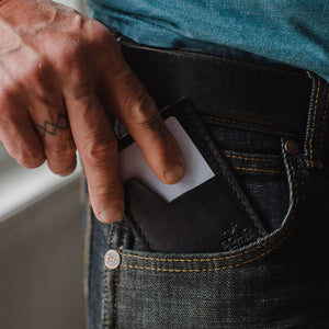 Slim Leather Card Holder wallet in black by Solid Leather in a front pocket of jeans.